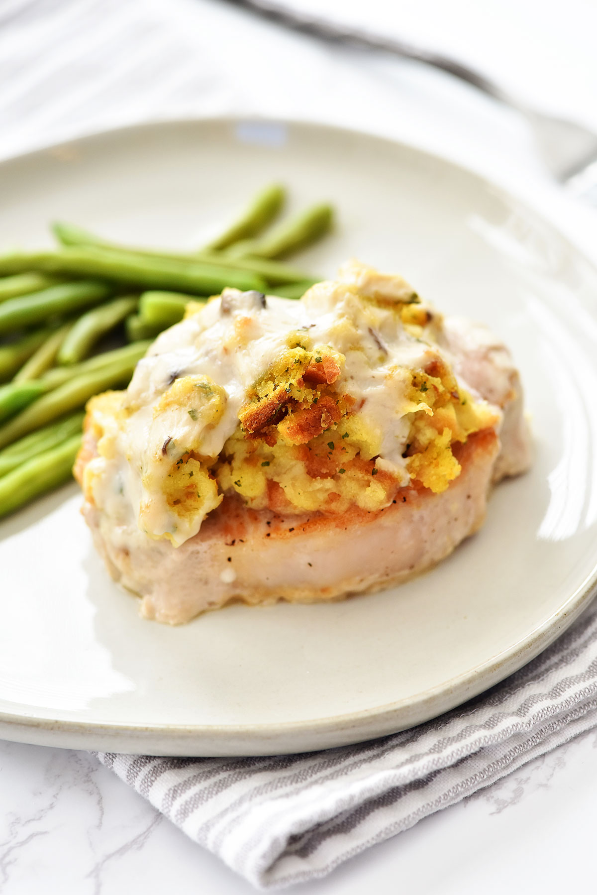 Stuffing-Topped Pork Chops are tender, flavorful chops with savory pork stuffing and creamy gravy on top. Life-in-the-Lofthouse.com