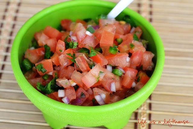 Pico de Gallo in a green bowl with a spoon