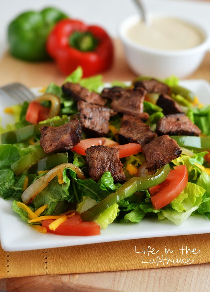 This Steak Fajita Salad is incredible and loaded with tender veggies, flat iron steak and drizzled with a delicious Chipotle ranch dressing. Life-in-the-Lofthouse.com