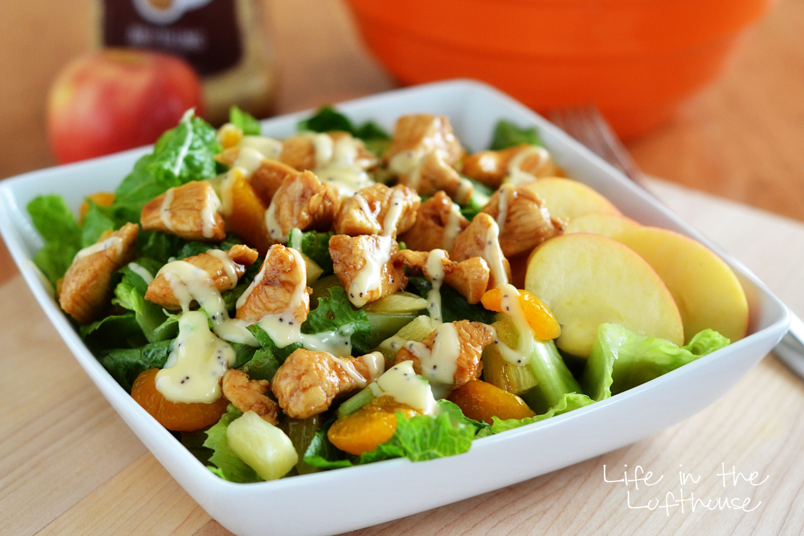 Asian Chicken Salad has romaine lettuce, pineapple, mandarin oranges, sliced apples, marinated chicken, sliced almonds and a drizzle of creamy poppy seed dressing. Life-in-the-Lofthouse.com