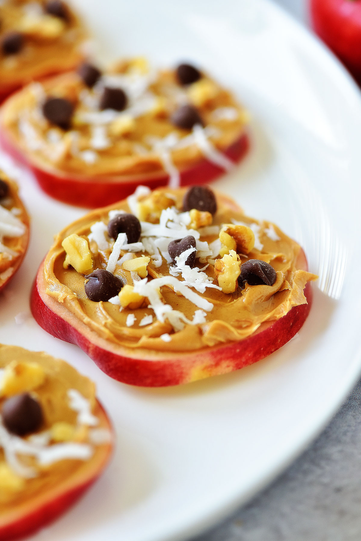 Apple Cookie Snacks are thin slices of apple covered in peanut butter, nuts, coconut and chocolate chips!