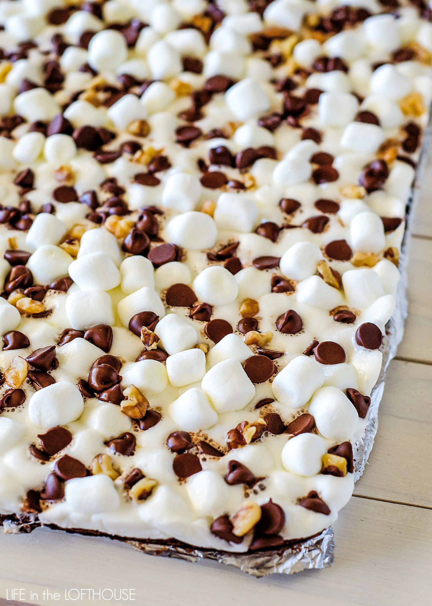 Rocky road brownies are soft and delicious brownies covered in mini marshmallows, chocolate chips and chopped walnuts. Life-in-the-Lofthouse.com