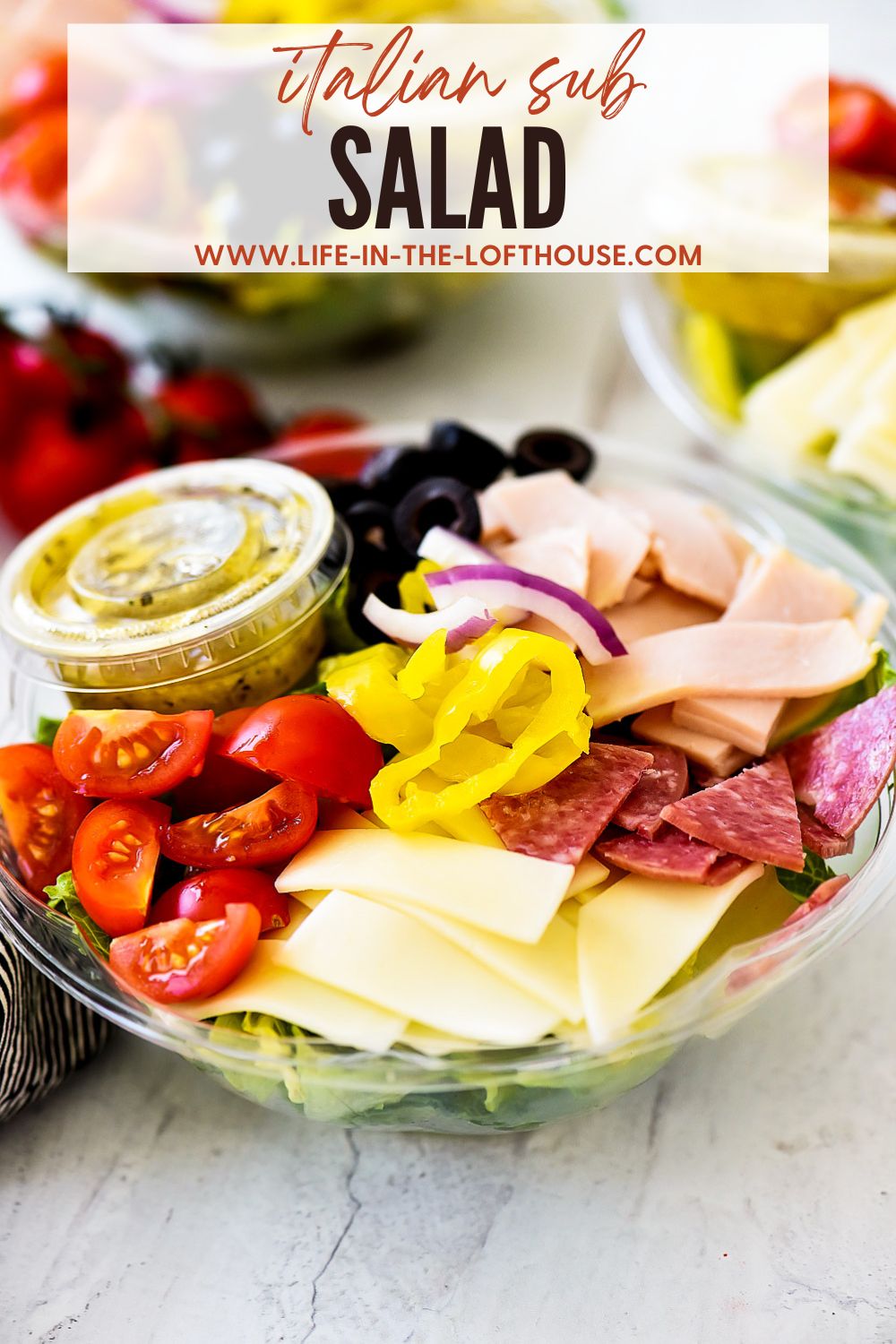 Italian Sub Salad is filled with sliced turkey, salami, provolone cheese, banana peppers, sliced olives and cherry tomatoes. Life-in-the-Lofthouse.com