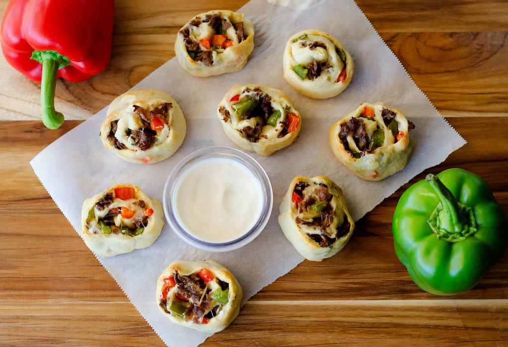 Philly cheese steak crescent pinwheels are filled with steak, cream cheese and bell peppers that are wrapped up in flaky crescent dough. Life-in-the-Lofthouse.com