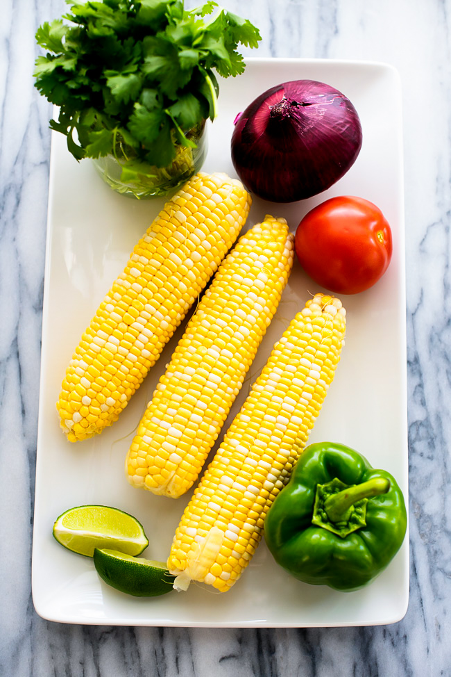 Summer corn salad is a flavorful salad filled with corn, bell peppers, tomato, red onion and fresh cilantro. Life-in-the-Lofthouse.com