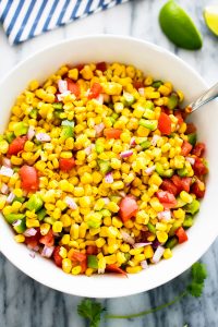 Summer corn salad is a flavorful salad filled with corn, bell peppers, tomato, red onion and fresh cilantro. Life-in-the-Lofthouse.com