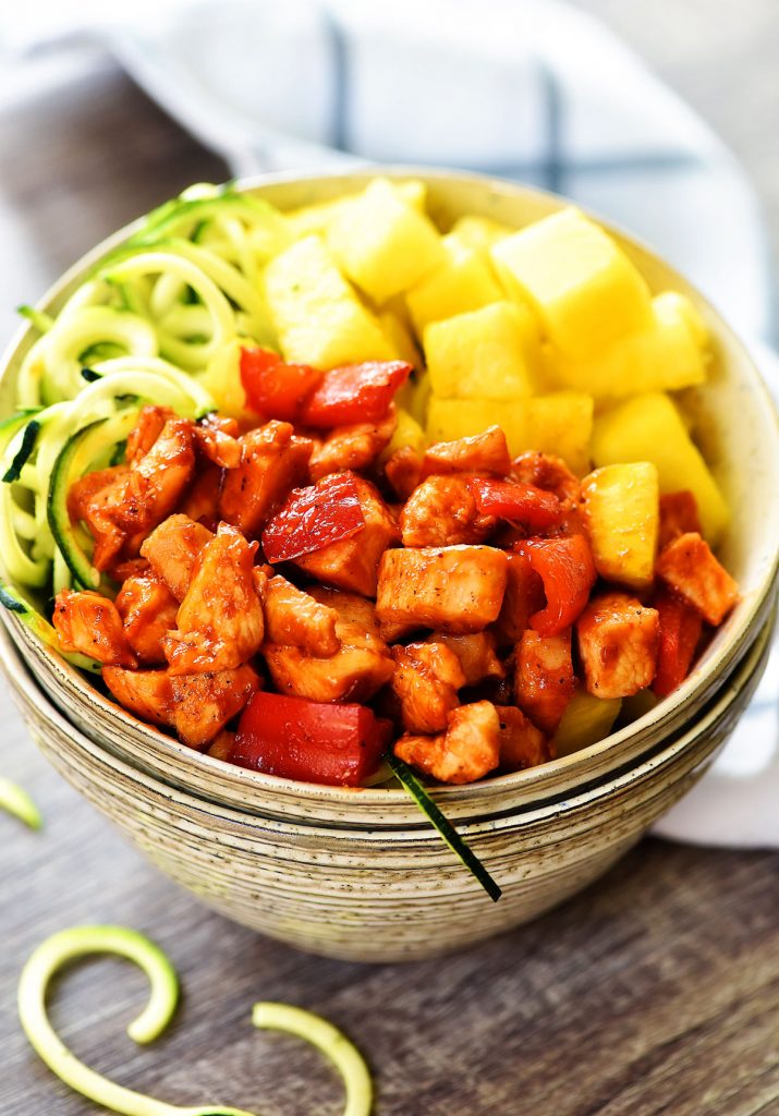 Hawaiian Chicken meal prep bowls are filled with seasoned barbecue chicken, bell pepper, fresh pineapple, red onion and zucchini noodles. Life-in-the-Lofthouse.com