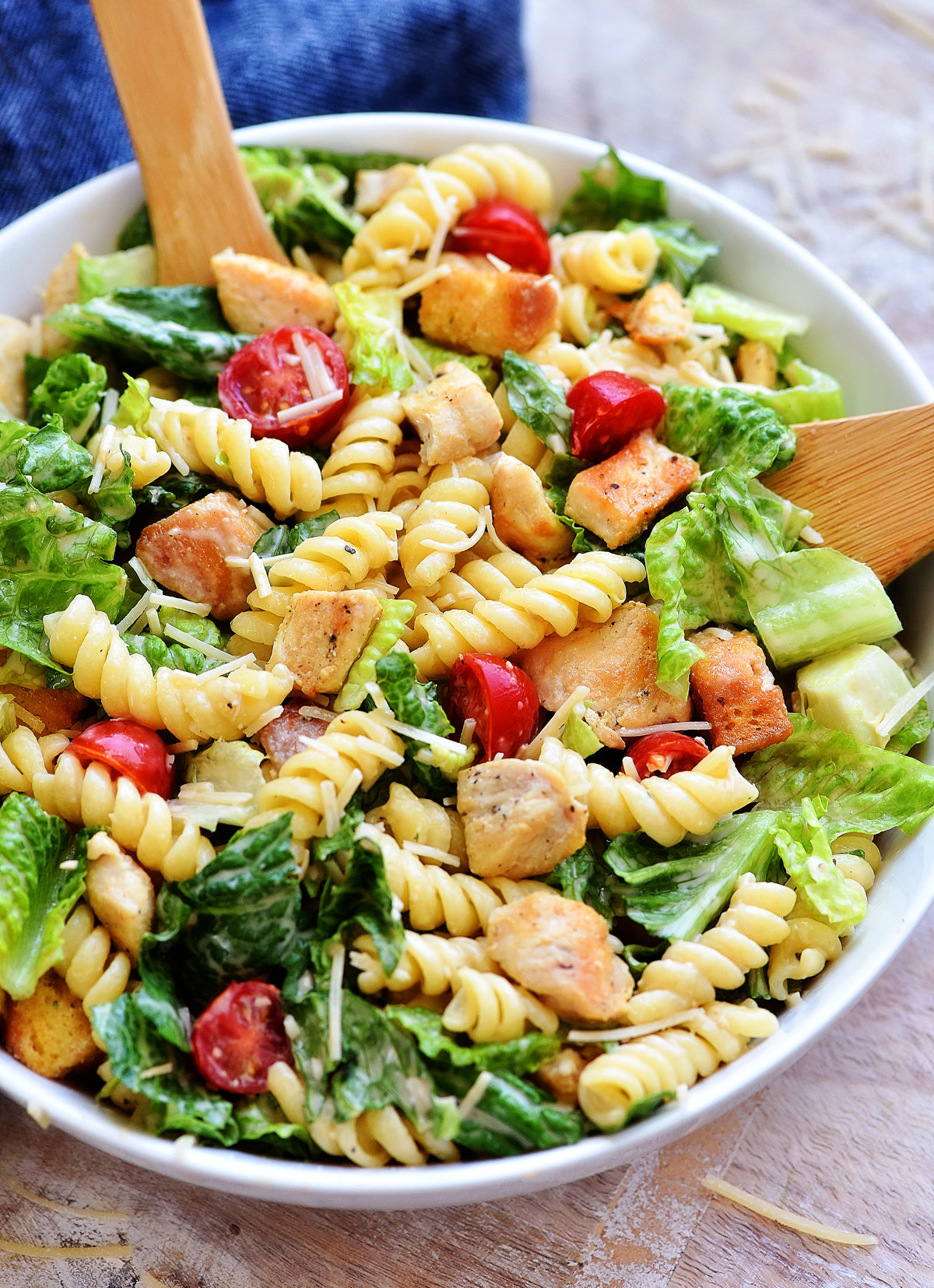 Chicken Caesar Pasta Salad is filled with grilled chicken, rotini pasta, croutons and tomatoes over a bed of romaine lettuce. Life-in-the-Lofthouse.com