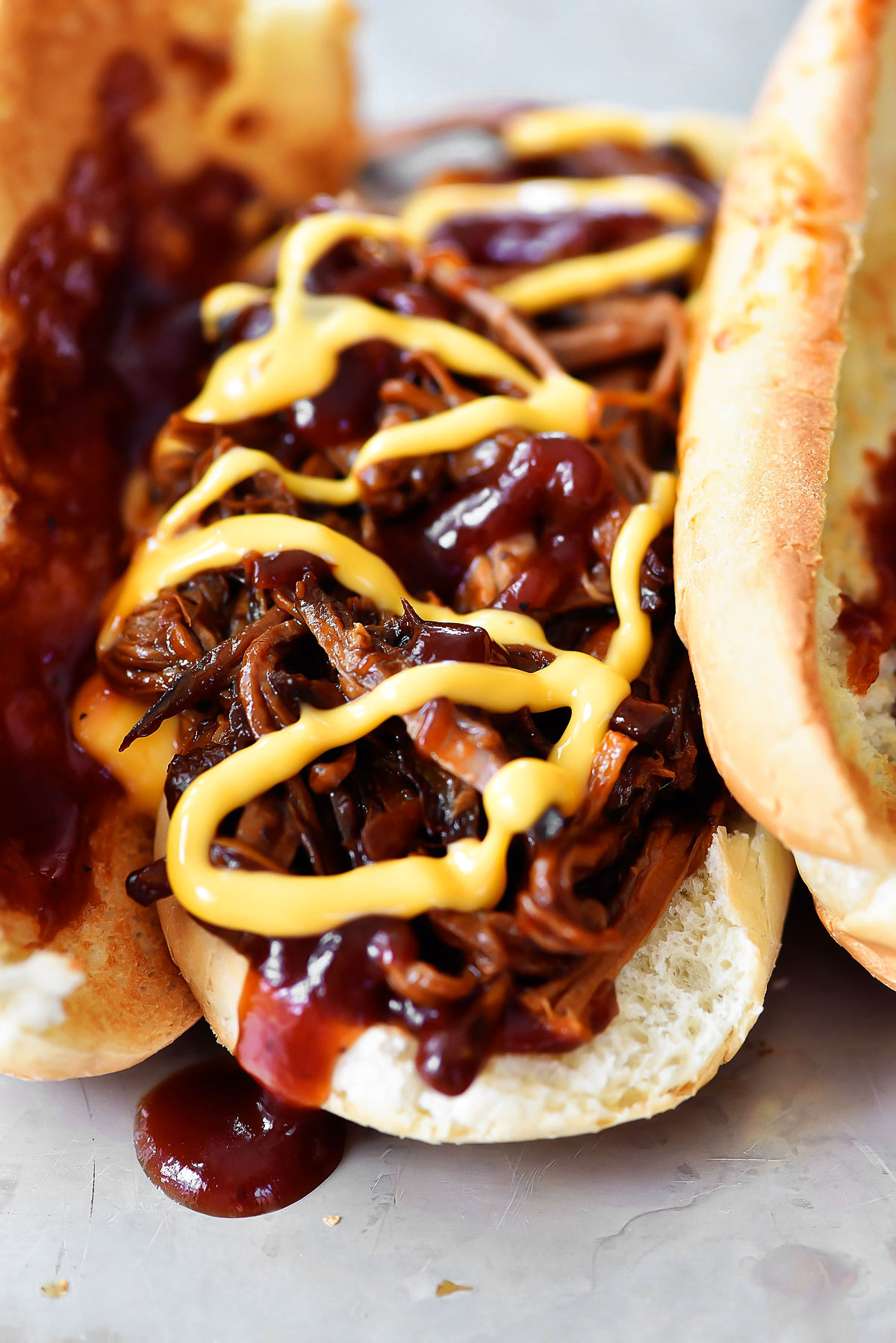 BBQ beef brisket sandwiches have tender BBQ Brisket loaded in a hoagie bun with drizzles of cheddar cheese. Life-in-the-Lofthouse.com