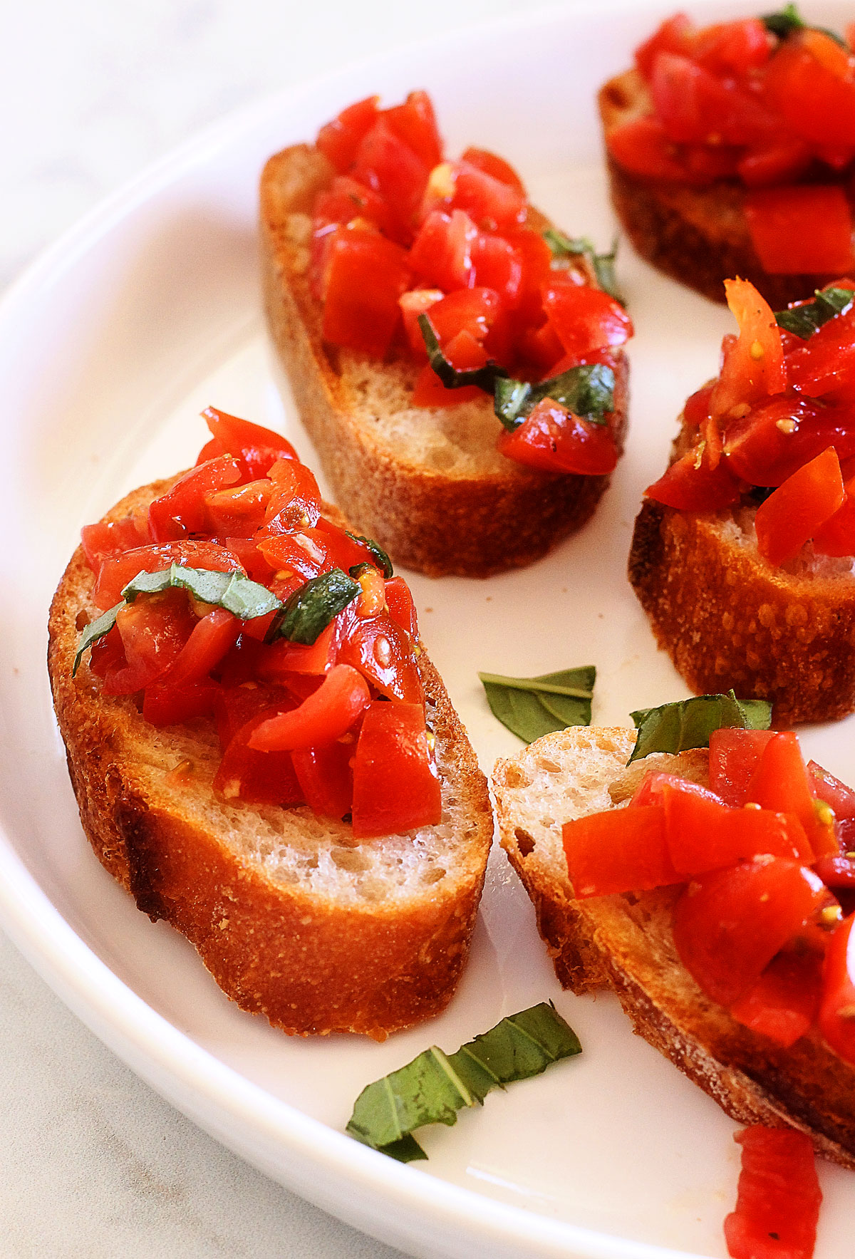 The Best Bruschetta are slices of a french baguette topped with fresh cherry tomatoes and basil that is full of Italian flavor. Life-in-the-Lofthouse.com 