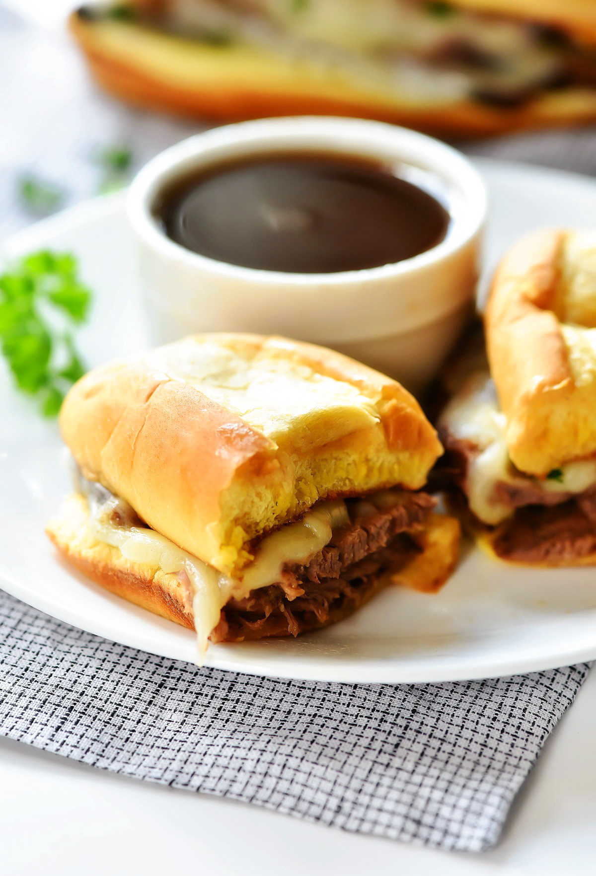 Slow Cooker French Dip Sandwiches are filled with tender slow cooked beef, topped with melty cheese and packed inside a toasty bun. Life-in-the-Lofthouse.com