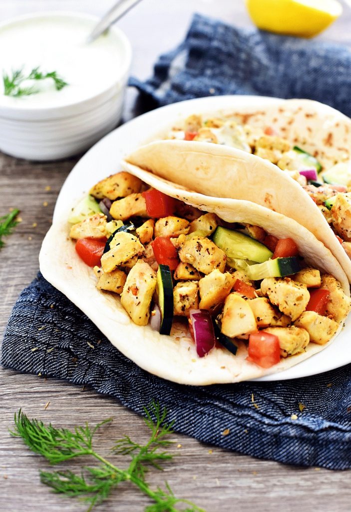 Greek Chicken Wraps are loaded with veggies, seasoned grilled chicken and Tzatziki sauce all wrapped inside a warm flatbread. Life-in-the-Lofthouse.com