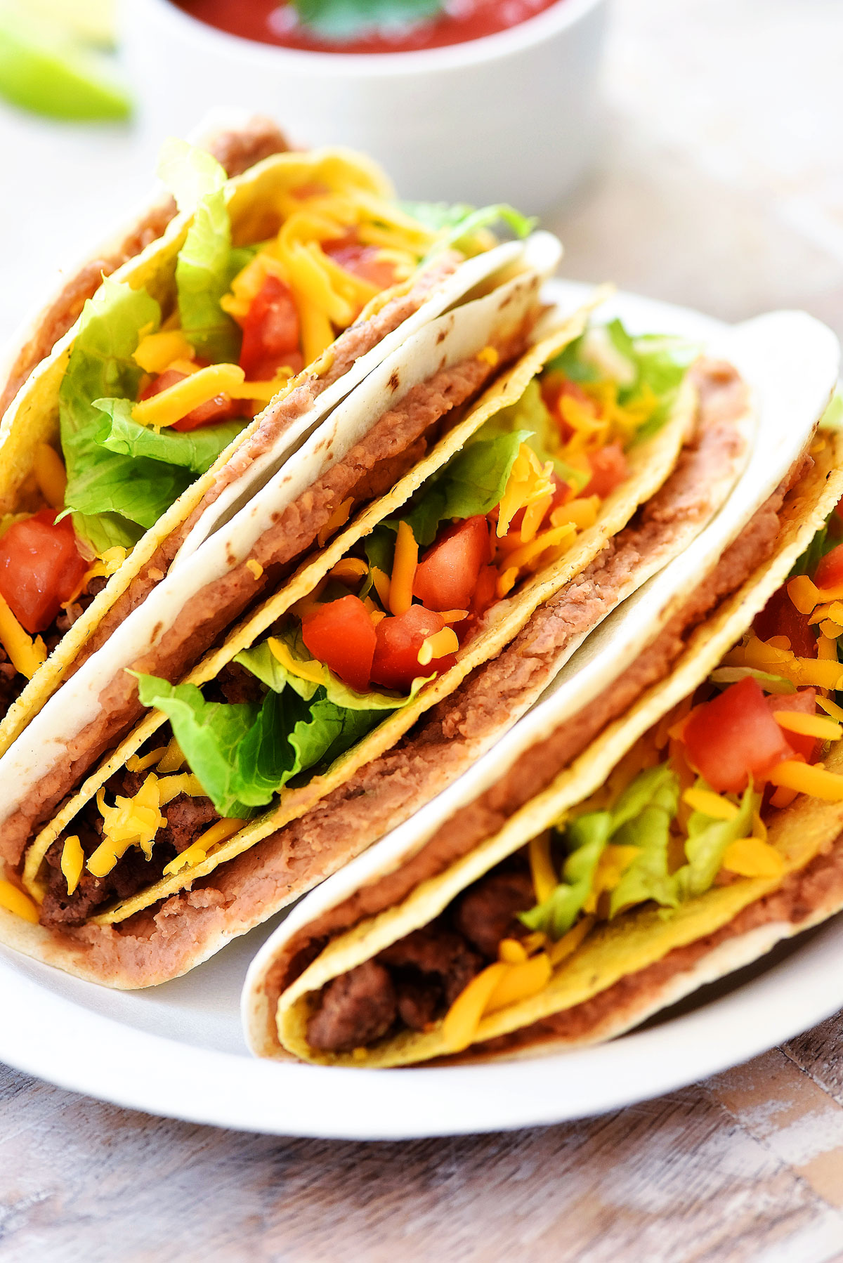 Double Decker Tacos start with a flour tortilla layered with beans, then inside there's a crispy beef taco filled with all your favorite taco toppings. Life-in-the-Lofthouse.com