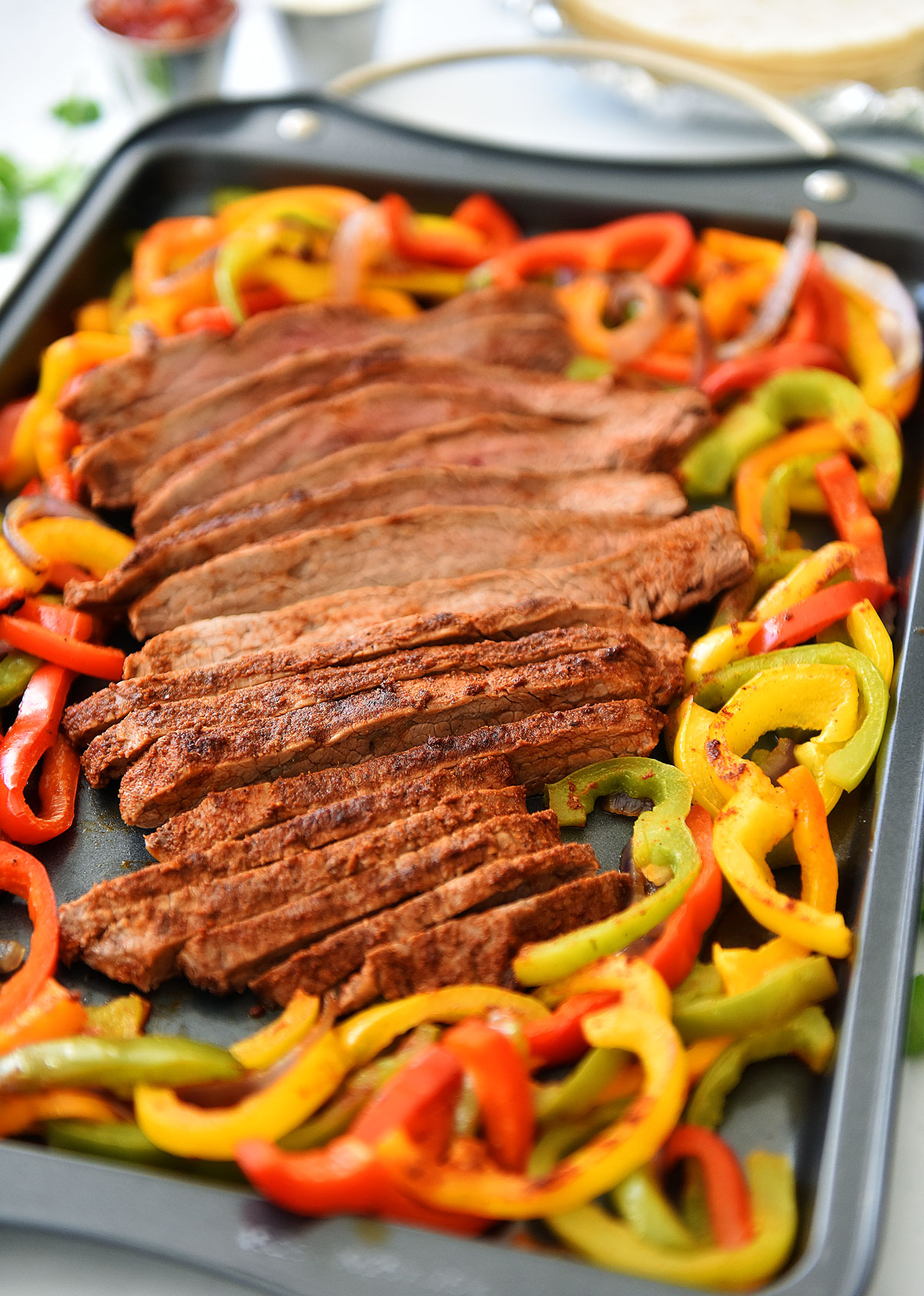 Sheet Pan Steak Fajitas are just like classic fajitas with grilled onions, bell peppers and steak. Life-in-the-Lofthouse.com
