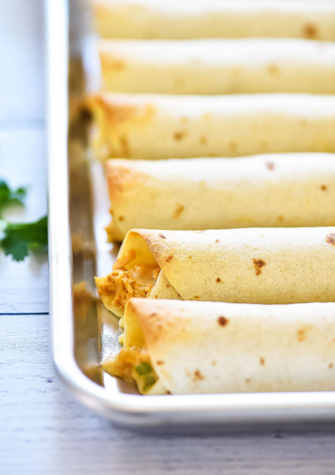 Baked Chicken Taquitos are a crispy flour tortilla wrapped around a warm center of creamy and cheesy Mexican chicken. Life-in-the-Lofthouse.com