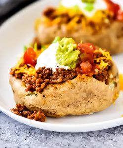Taco Potatoes are loaded with seasoned ground beef, cheese, lettuce, sour cream and salsa all over a baked potato. Life-in-the-Lofthouse.com