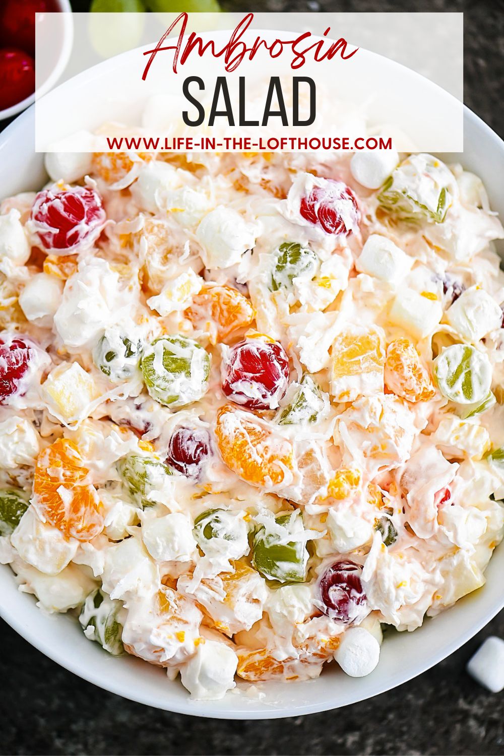 Ambrosia salad has apples, oranges, pineapples and grapes all tossed together in whipped topping and shredded coconut. Life-in-the-Lofthouse.com
