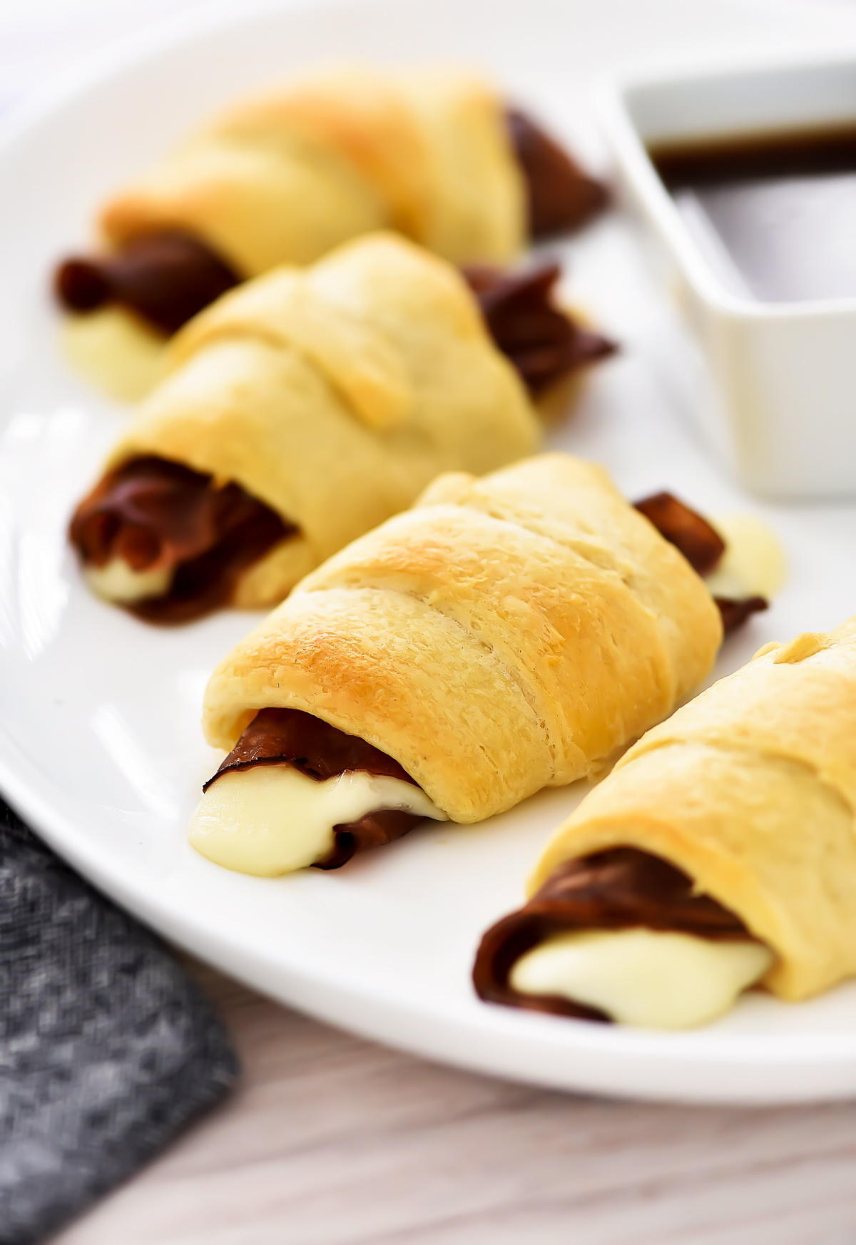 French Dip Crescents are savory little beef sandwiches filled with roast beef and cheese inside golden crescent rolls.