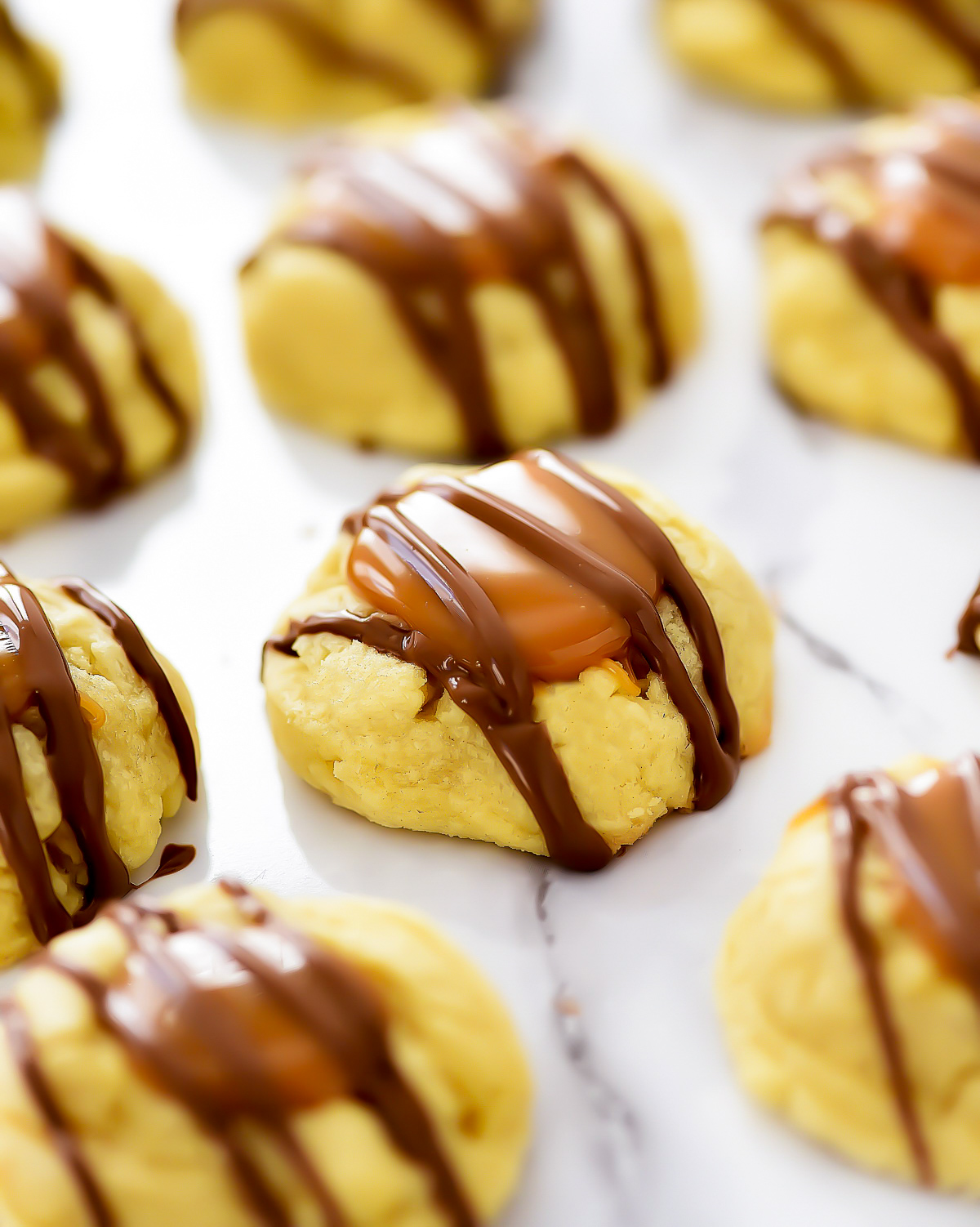 Twix Cookies start with a buttery thumbprint cookie topped with caramel and milk chocolate. Life-in-the-Lofthouse.com