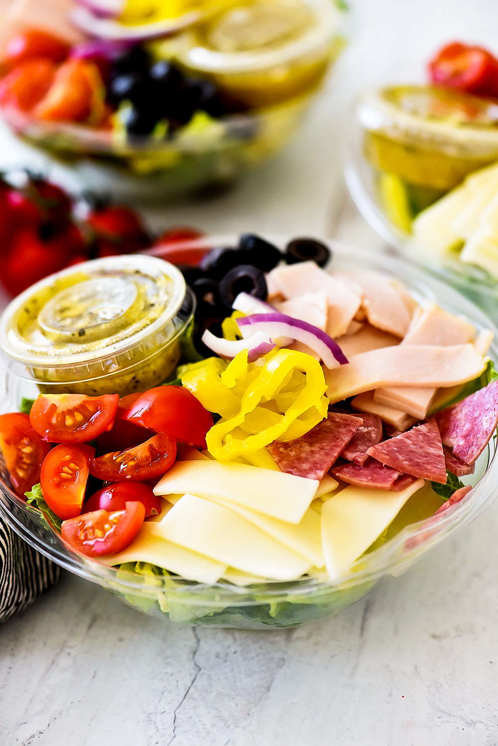 Italian Sub Salad is filled with sliced turkey, salami, provolone cheese, banana peppers, sliced olives and cherry tomatoes. Life-in-the-Lofthouse.com