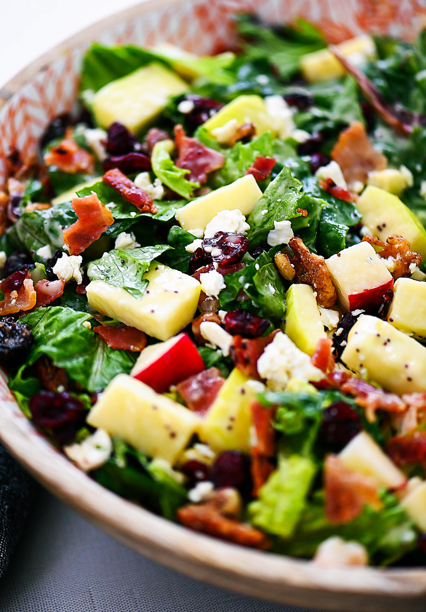 Autumn chopped salad is filled with chopped leafy greens, apples, cranberries, bacon, pecans and feta cheese. Life-in-the-Lofthouse.com