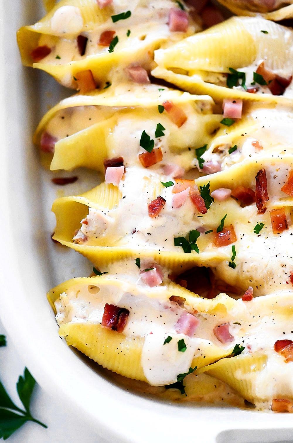 Jumbo pasta shells stuffed with chicken, ham and bacon covered in Alfredo sauce and cheese.