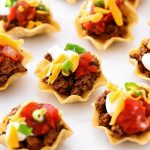 Taco Bites are small tortilla chips topped with taco meat and toppings.