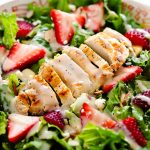 Strawberry Chicken Salad is filled with chopped romaine lettuce, sprinkles of sliced almonds, sliced strawberries and grilled chicken.